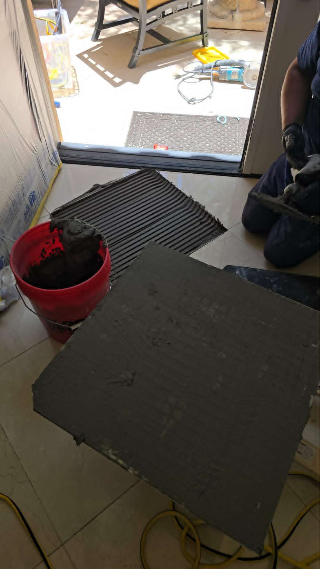Properly combed mortar bed with directional troweling on a prepared subfloor before tile installation in an Arizona new construction home showing the correct full coverage technique that prevents hollow tile failure